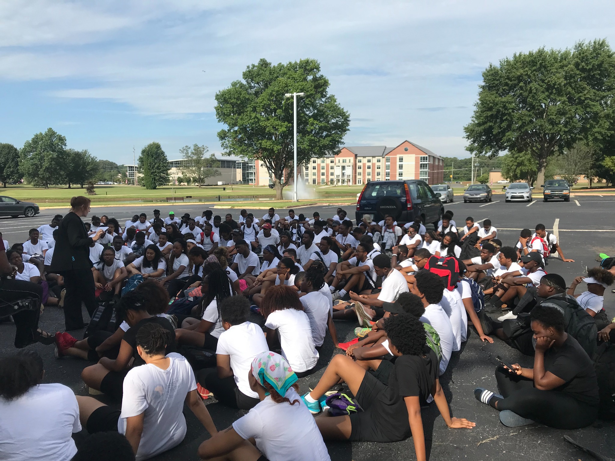 A large group of students gathered outdoors on a college campus